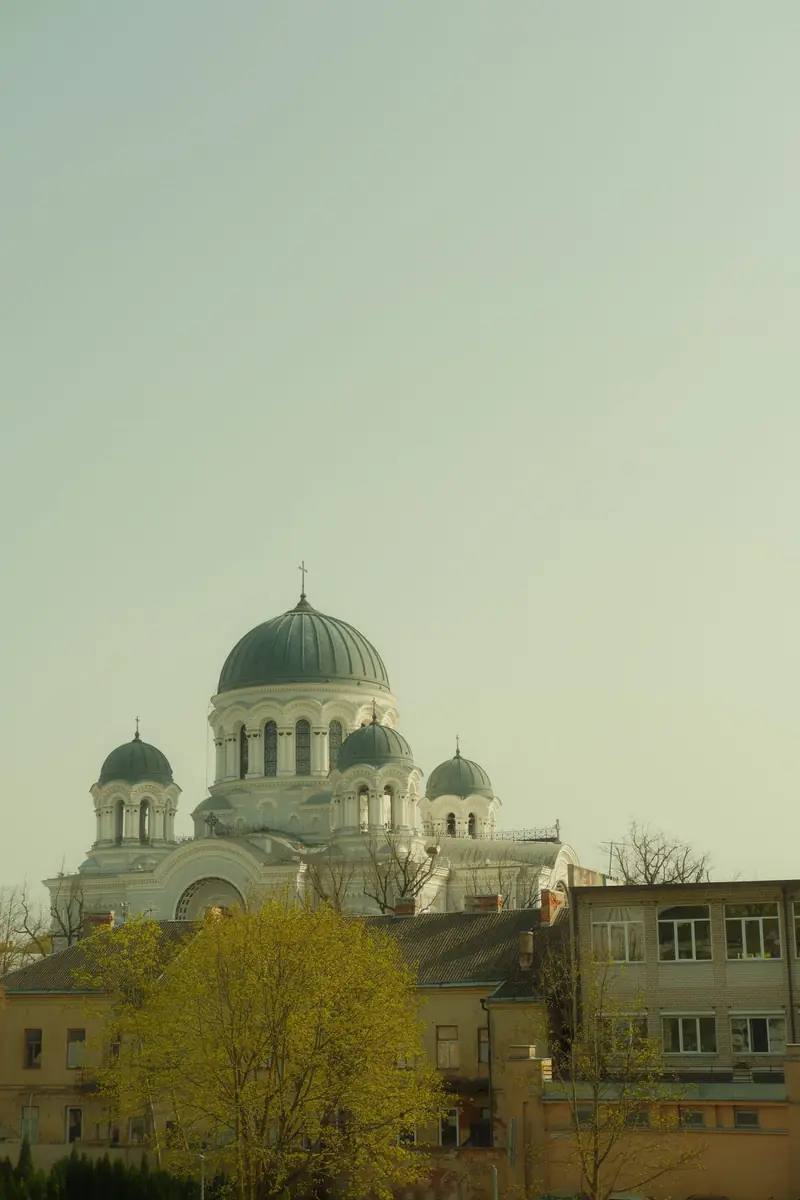 Bažnyčia su žaliais kupolais tarp medžių